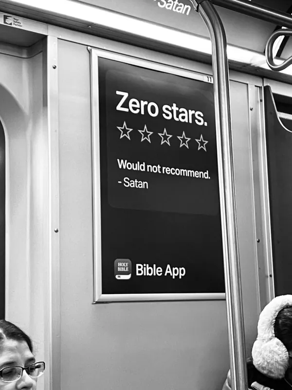 Subway ad for a Bible app styled as a customer review: 'Zero stars. Would not recommend. — Satan.'